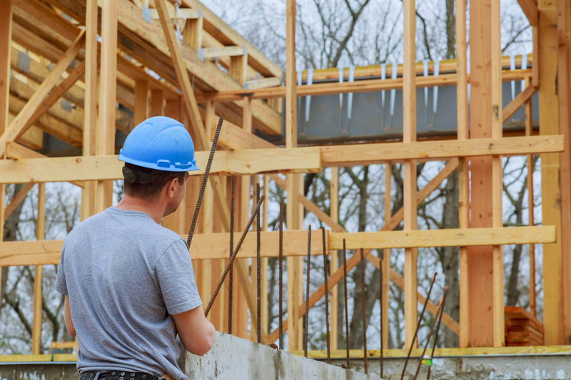 A building inspector surveys a new home build in construction site checking new building in progress building inspector